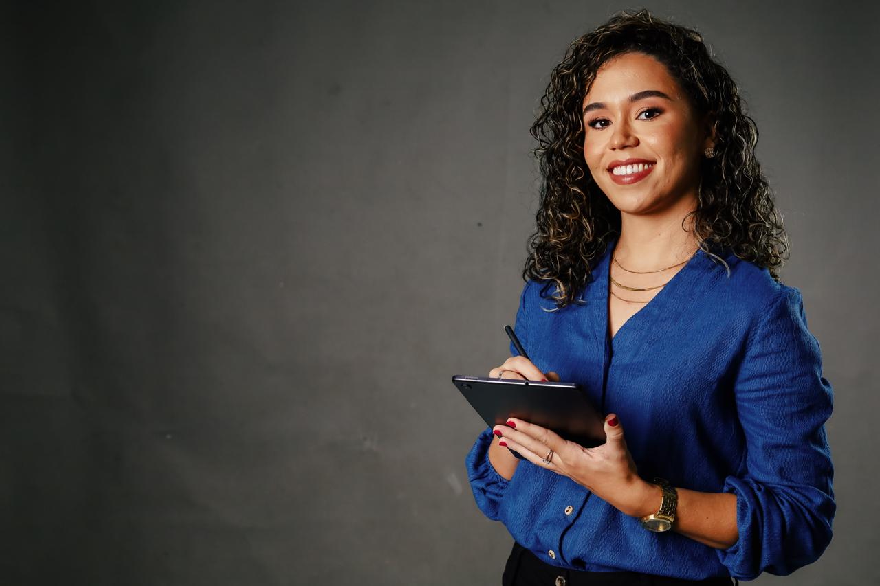 Jessiane Cunha com um tablet, sorrindo